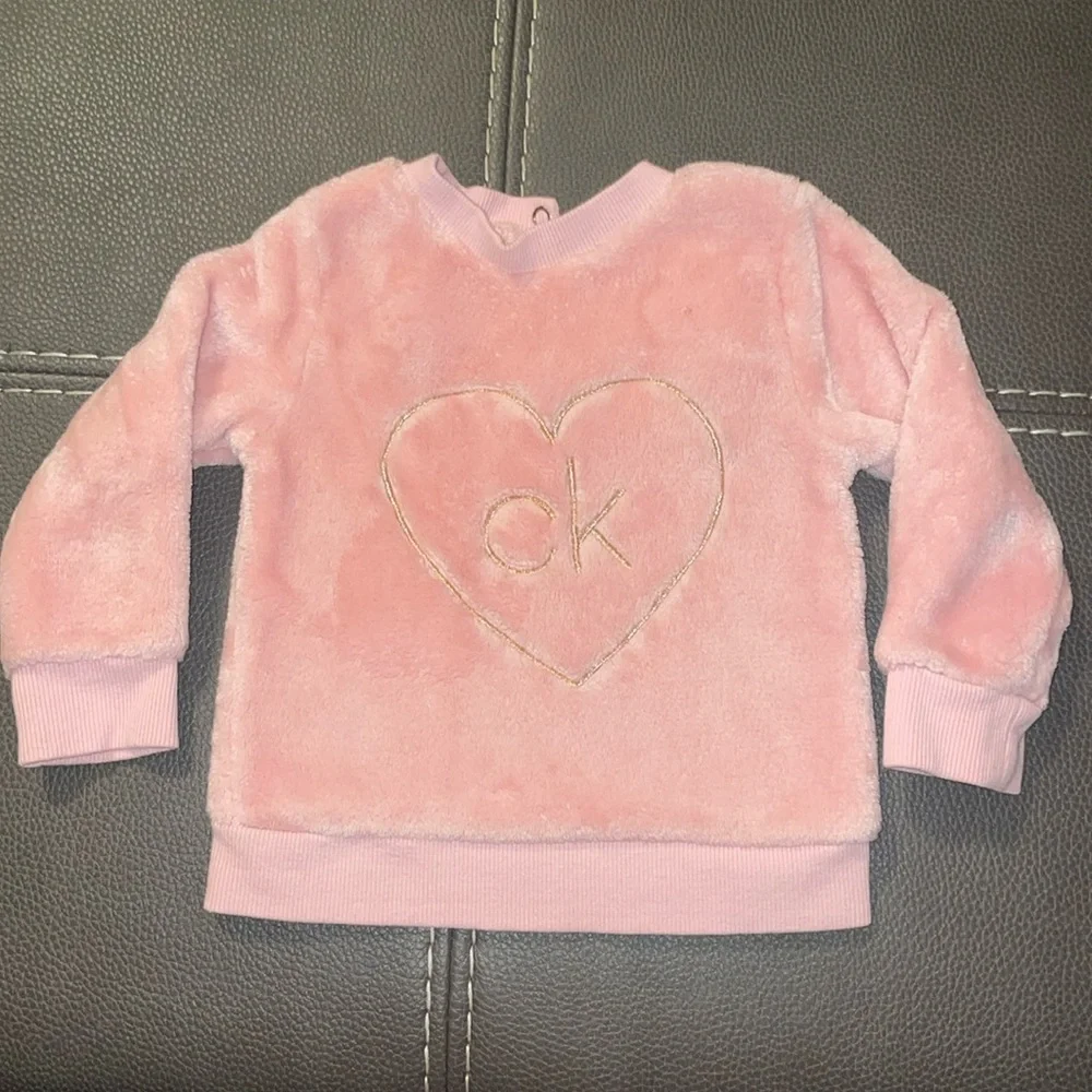 Calvin Klein size 12 months. Soft pink two snap buttons behind neck. GUC.